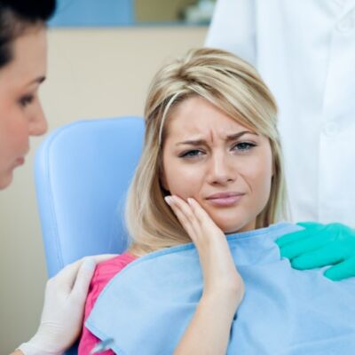 Young woman with toothache at the dentist